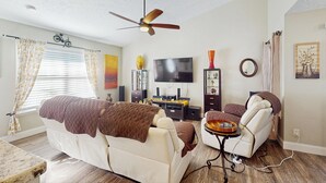 A living room with a sofa, a coffee table, a TV, and a ceiling fan. - Dog-friendly Family Home w/ Patio & Fire Pit! (Richmond Hill)