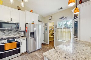 A modern kitchen with white cabinets, stainless steel appliances, a granite countertop, and pendant lighting. - Dog-friendly Family Home w/ Patio & Fire Pit! (Richmond Hill)