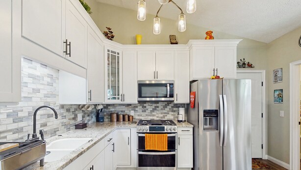 A modern kitchen with white cabinets, a stainless steel refrigerator, an oven, a microwave, and a granite countertop. - Dog-friendly Family Home w/ Patio & Fire Pit! (Richmond Hill)