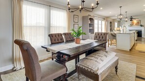 A dining area with a wooden table, upholstered chairs, and a chandelier. - Scenic Sandia Mtn Views! Cozy Rio Rancho Retreat (Rio Rancho)
