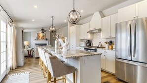 A modern kitchen with a central island, stainless steel appliances, and a chandelier. - Scenic Sandia Mtn Views! Cozy Rio Rancho Retreat (Rio Rancho)