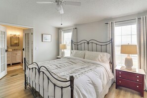 A bedroom with a bed, bedside tables, a ceiling fan, and a window with curtains. - Scenic Sandia Mtn Views! Cozy Rio Rancho Retreat (Rio Rancho)