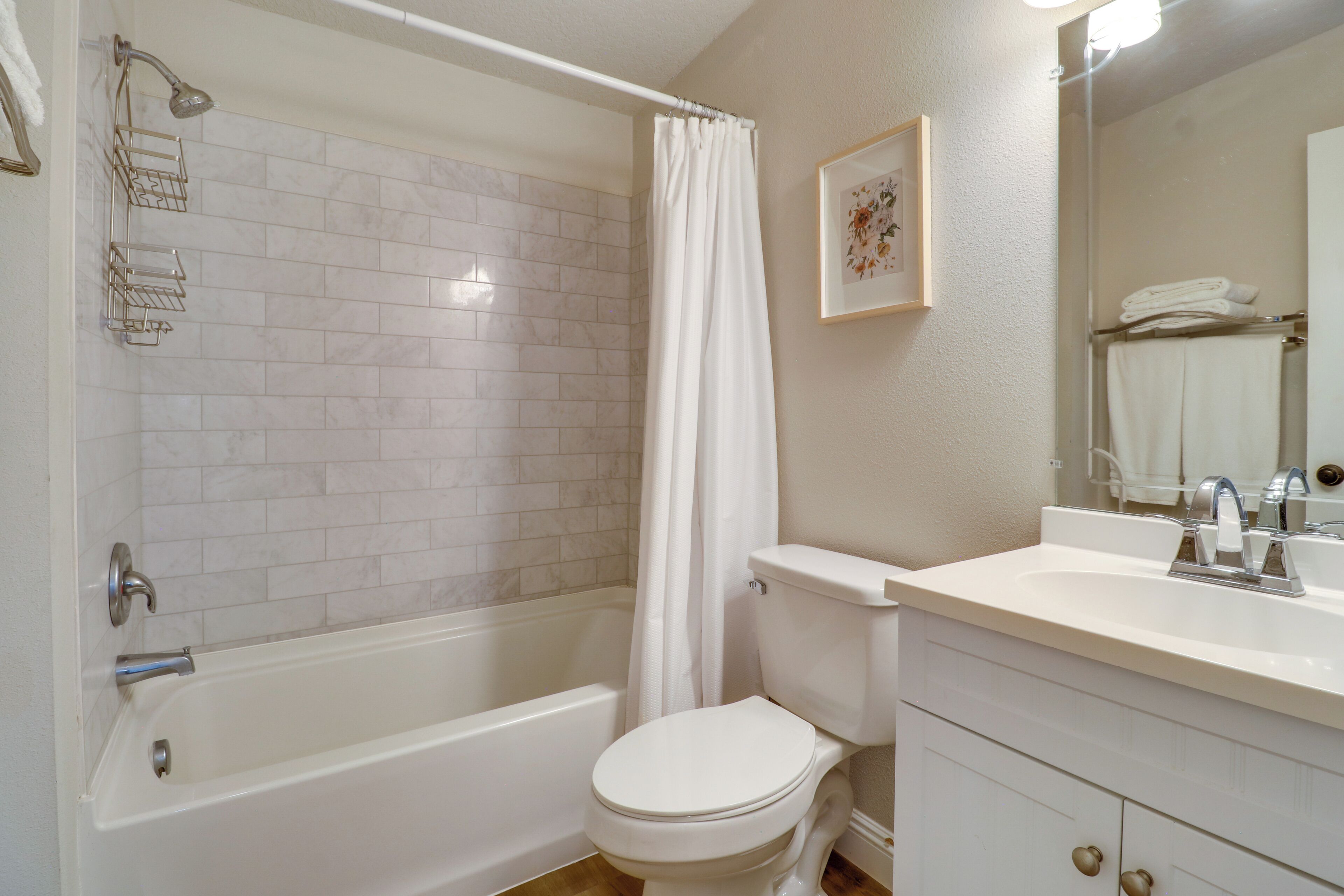 A bathroom with a bathtub, toilet, and sink.