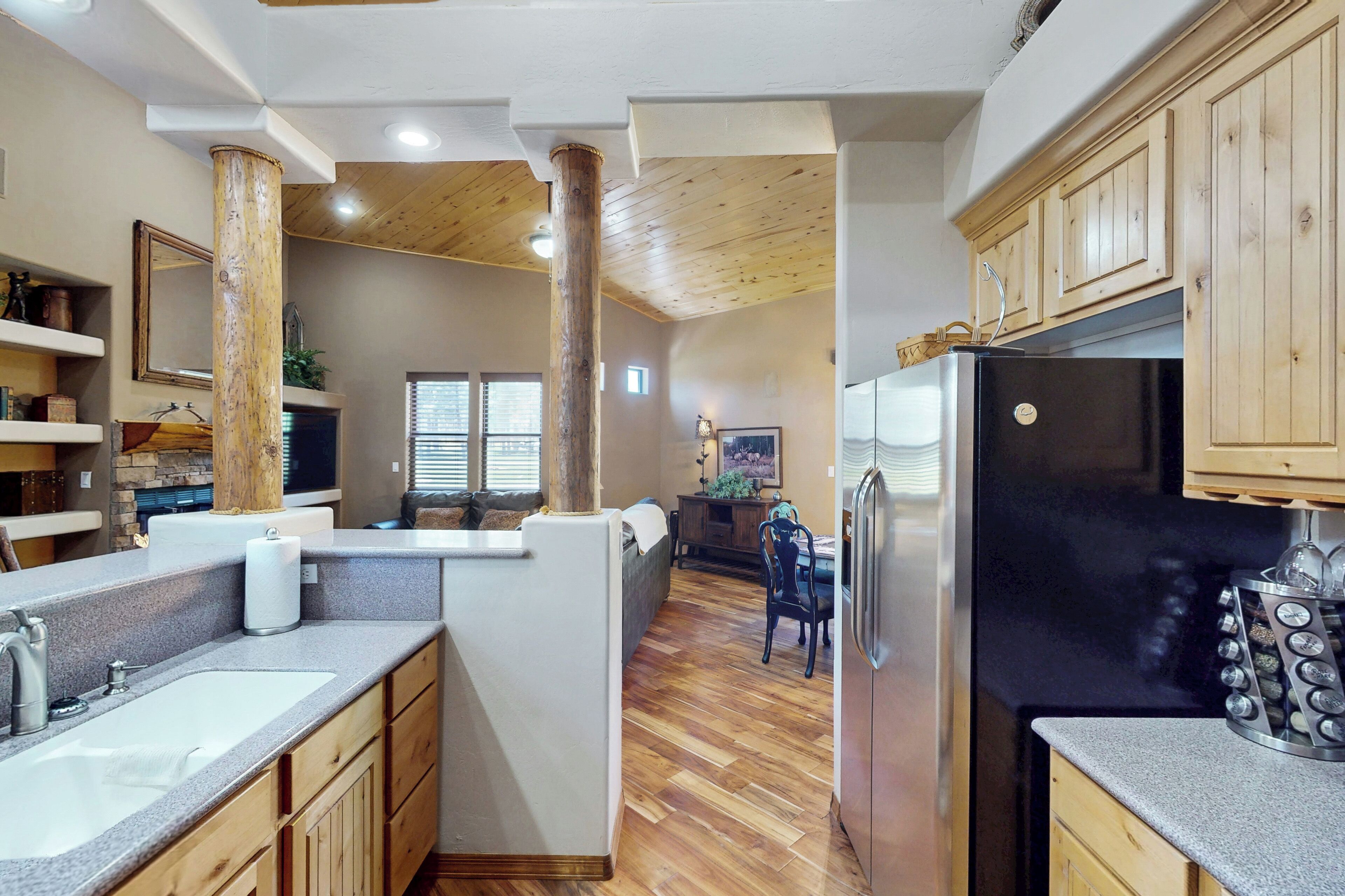 A modern kitchen with wooden cabinets, a large refrigerator, and a central island.