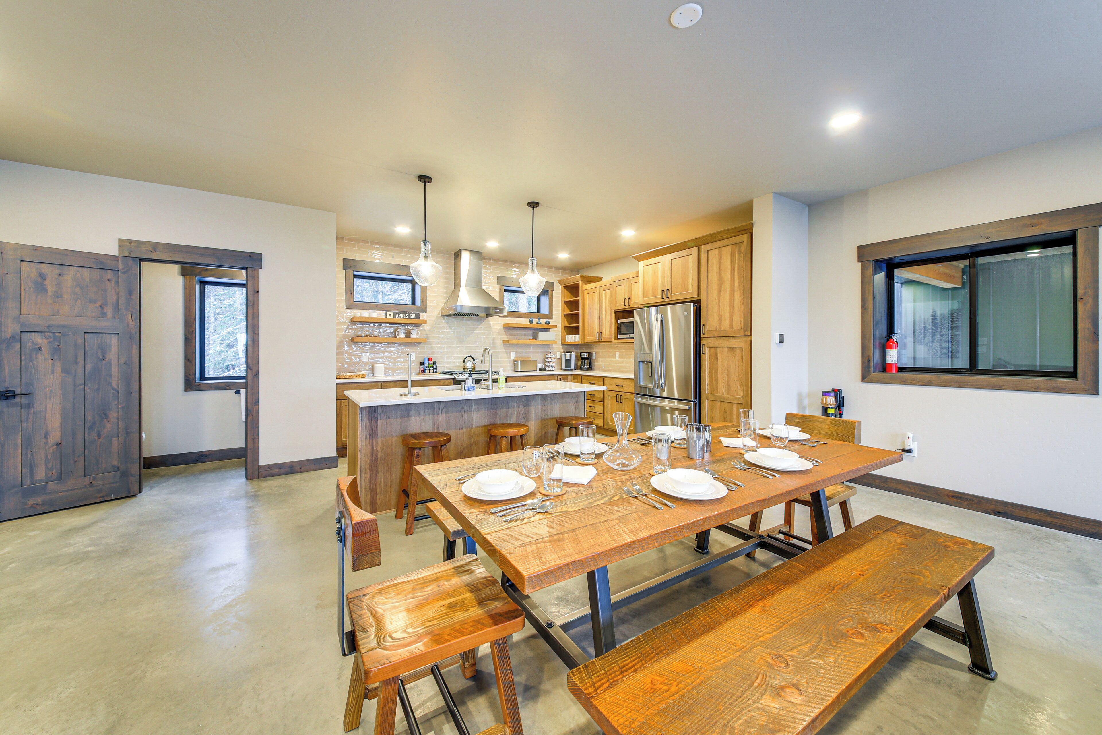 A modern kitchen with a central island, wooden cabinetry, and stainless steel appliances.