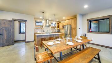 A modern kitchen with a central island, wooden cabinetry, and stainless steel appliances.
