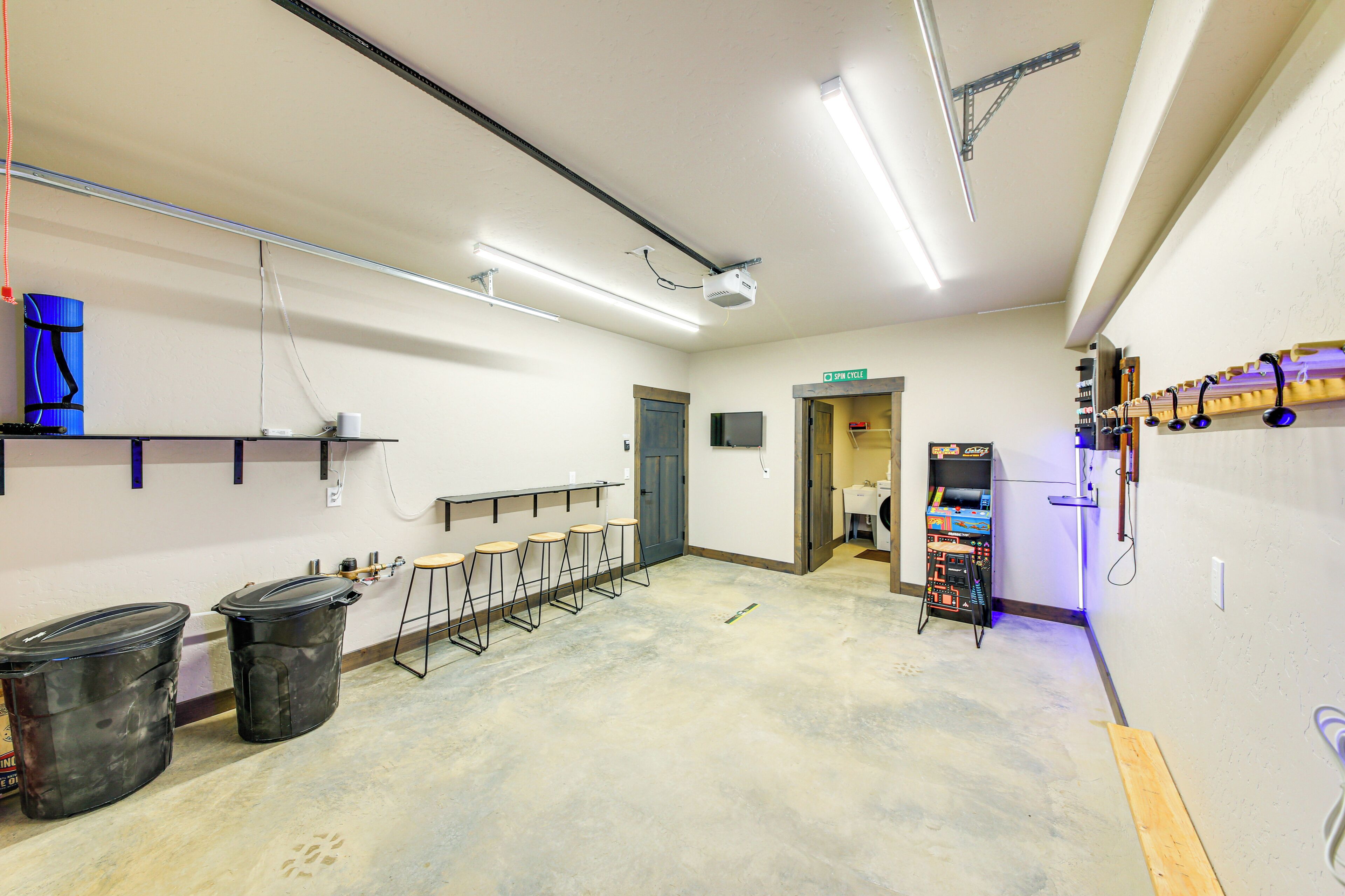 Uma sala de conferência com uma mesa comprida, cadeiras, um projetor e uma máquina de lavar roupa.