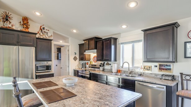 A modern kitchen with dark cabinetry, stainless steel appliances, and a granite countertop. - Mtn Views, 15 Mi to Dtwn Kingman: Family Home! (Kingman)