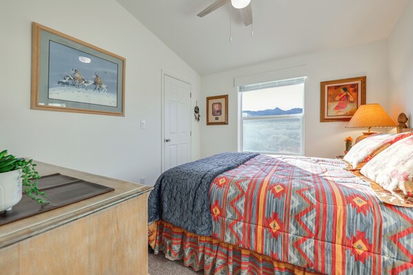 A bedroom with a bed, a desk, a window with a view, and a ceiling fan. - Mtn Views, 15 Mi to Dtwn Kingman: Family Home! (Kingman)