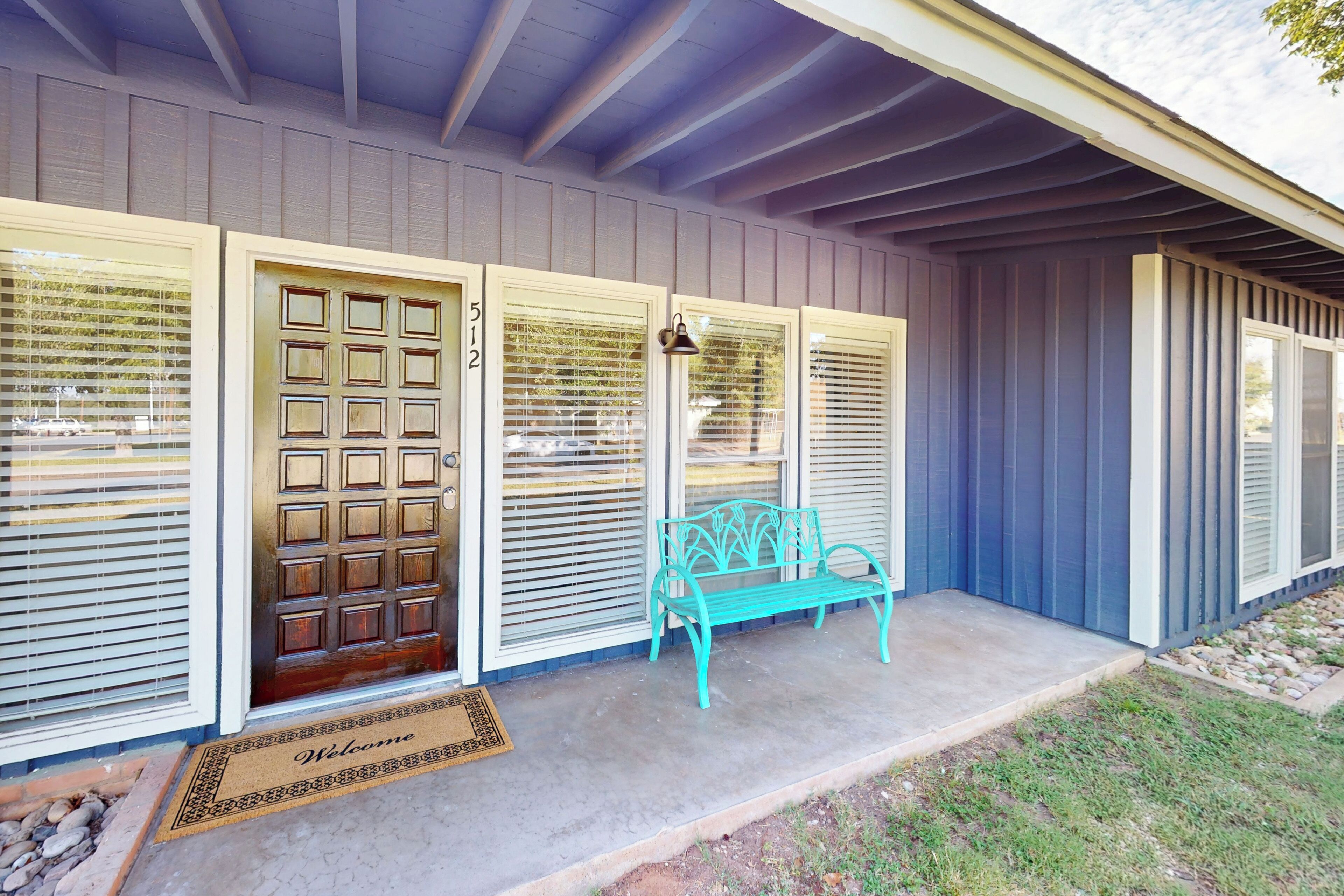 A house with a front door, a bench, and a mailbox.