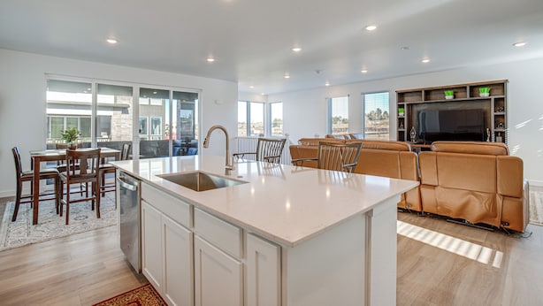 A modern kitchen with a central island, dining area with chairs, a sofa, and a TV. - 8 Mi to Denver Tech Center: Business-ready Retreat (Centennial)