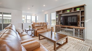 A modern living room with a leather sofa, a coffee table, and a TV stand with shelves. - 8 Mi to Denver Tech Center: Business-ready Retreat (Centennial)