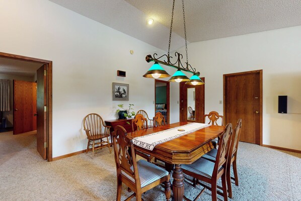 A dining room with a wooden table, chairs, and a chandelier. - Cozy, Walkable Helena Apartment! Dogs Welcome (Helena)
