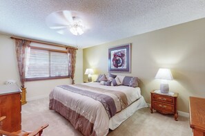 A bedroom with a bed, bedside lamps, a ceiling fan, a window with curtains, and a framed picture on the wall. - 2BR Lovely Home w/ Outdoor Patio & Fire Pit (Sun City)