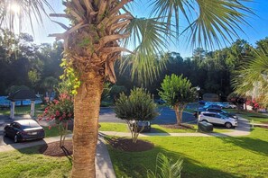 A parking lot with cars, a palm tree, and a gazebo in the background. - Longs Cozy Haven: Stylish, Accessible Retreat (Longs)