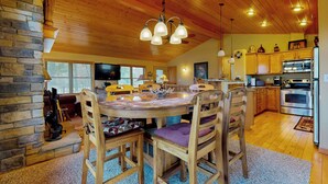 A cozy kitchen with wooden cabinets, a dining table with chairs, and a stone fireplace. - Pool & Beach Access! 'lake Arrowhead Hideaway' (Nekoosa)