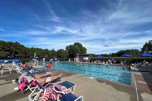 Un área de piscina con sillones de descanso y sombrillas.