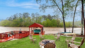 Une terrasse avec des chaises et un belvédère offrant une vue sur une rivière.