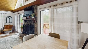Un salon chaleureux avec une cheminée, une table à manger et un coin salon confortable.