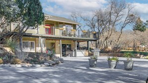 A two-story house with a balcony, a covered patio, and potted plants. - Private Hot Tub, 4 Mi to Usafa: Cozy Apartment! (Colorado Springs)
