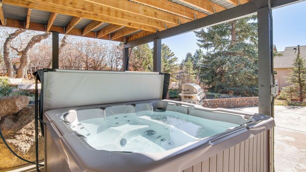 A hot tub under a wooden pergola with a view of trees and a house in the background. - Private Hot Tub, 4 Mi to Usafa: Cozy Apartment! (Colorado Springs)