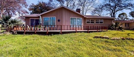 A single-story house with a porch, large windows, and a star decoration on the wall.