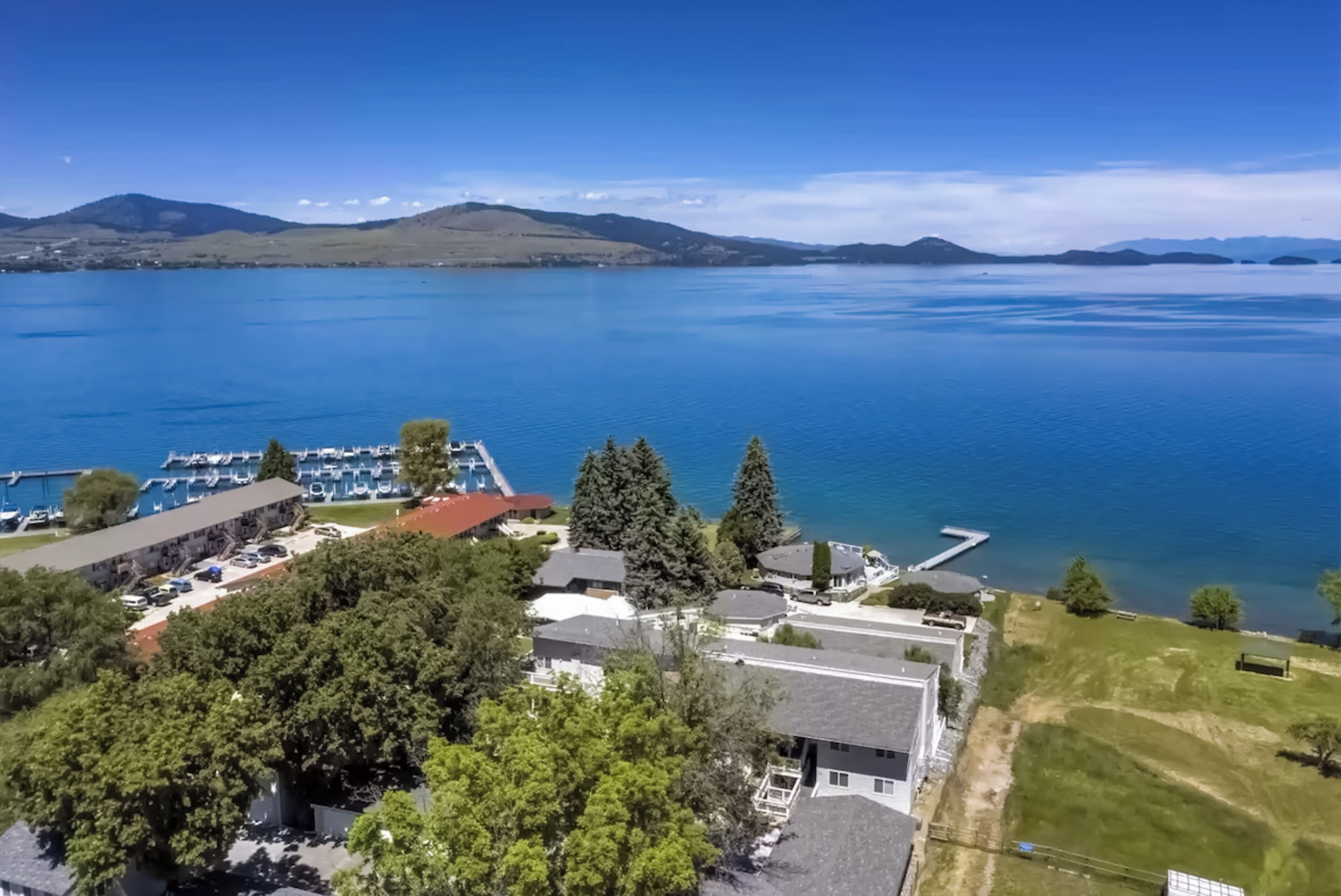 A lakeside property with a marina, buildings, and surrounding hills.
