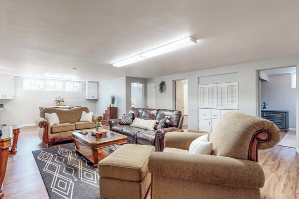 A spacious living room with a brown leather sofa, beige armchairs, and a wooden coffee table. - 2BR Dog-friendly Duplex Close to Boise w/ W & D (Caldwell)