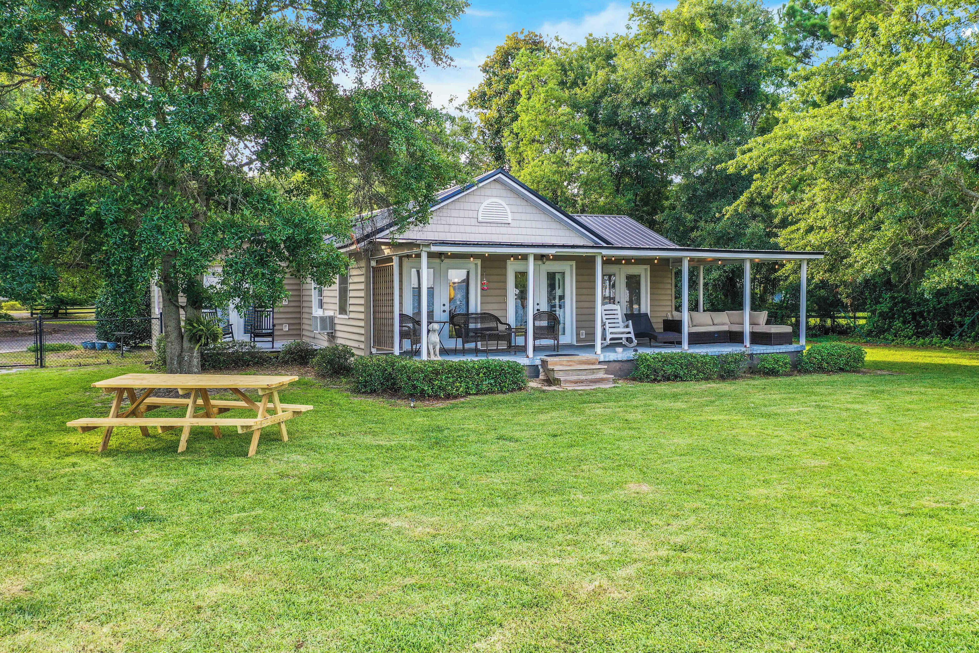 A small, single-story house with a porch and a picnic table in front.