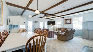 A spacious living area with a dining table, chairs, a sofa, and a television. - 2BR Lakefront Getaway w/ Dock & Boat Launch (Bonneau)
