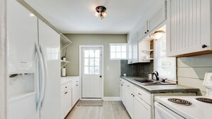 A kitchen with white cabinets, a refrigerator, a stove, and a sink. - 2BR Lakefront Getaway w/ Dock & Boat Launch (Bonneau)