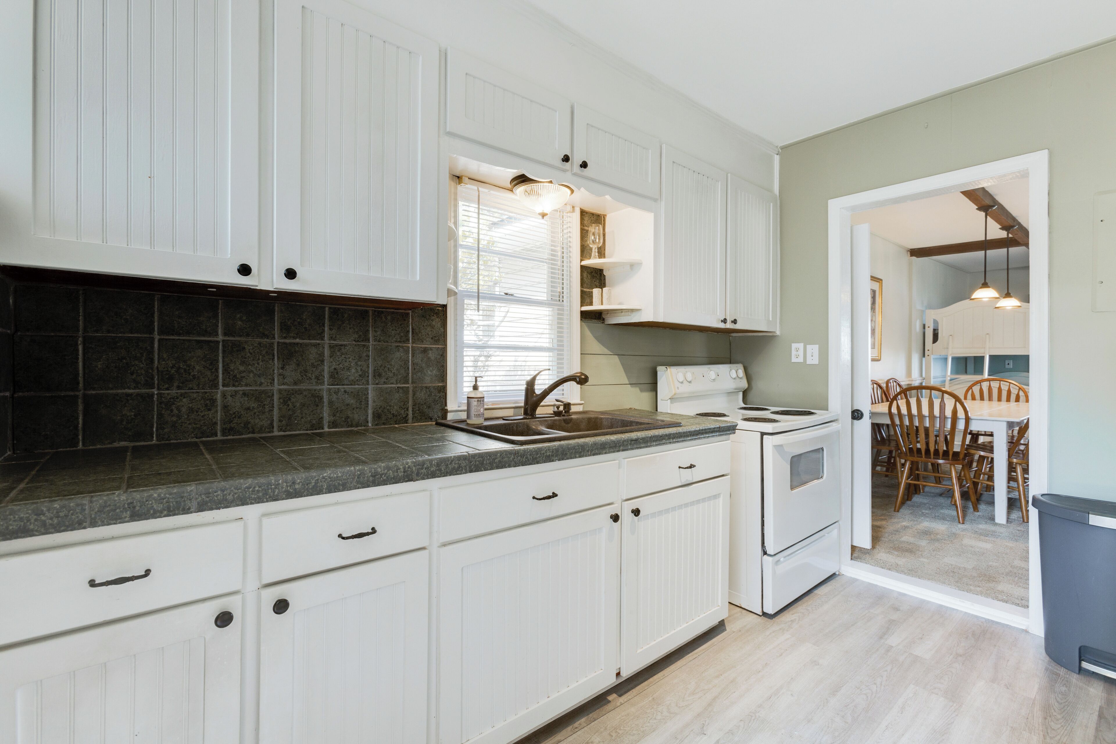 A kitchen with white cabinets, a granite countertop, and a built-in oven.