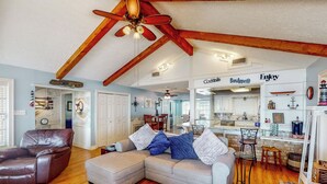 A spacious living room with a large sectional sofa, a leather armchair, and a dining area with a kitchen in the background. - 'harbor Haven' w/ Dock: Lake Livingston Home (Livingston)