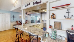 A kitchen with a marble countertop, bar stools, and a sign that reads "Cocktails Bon Appetit." - 'harbor Haven' w/ Dock: Lake Livingston Home (Livingston)