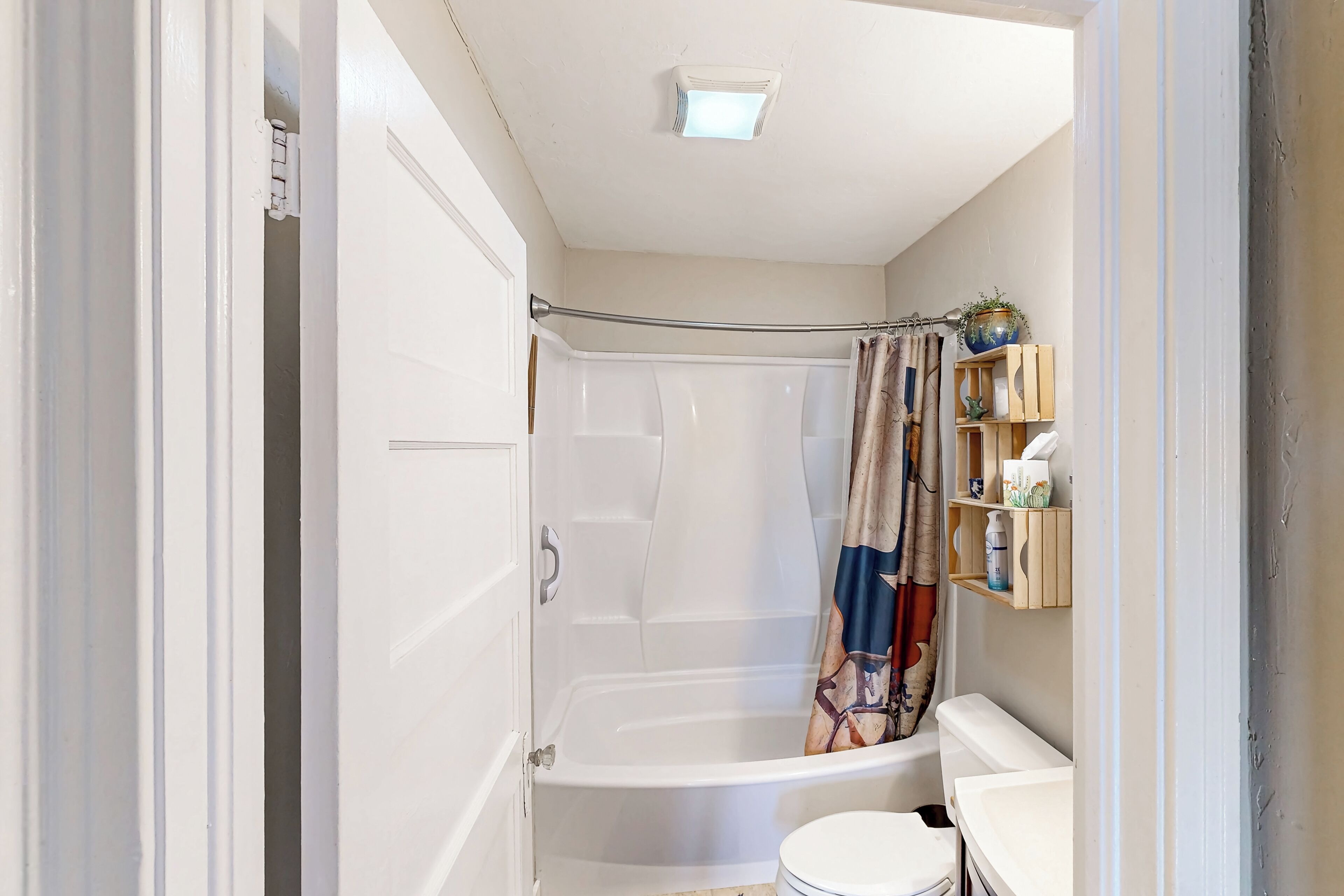 Un baño con bañera, inodoro y cortina de ducha.