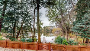 A wooden pathway leading to a wooden bridge over a calm body of water, surrounded by trees and a wooden fence. - Salisbury Waterfront: Schumaker Pond Paradise! (Salisbury)