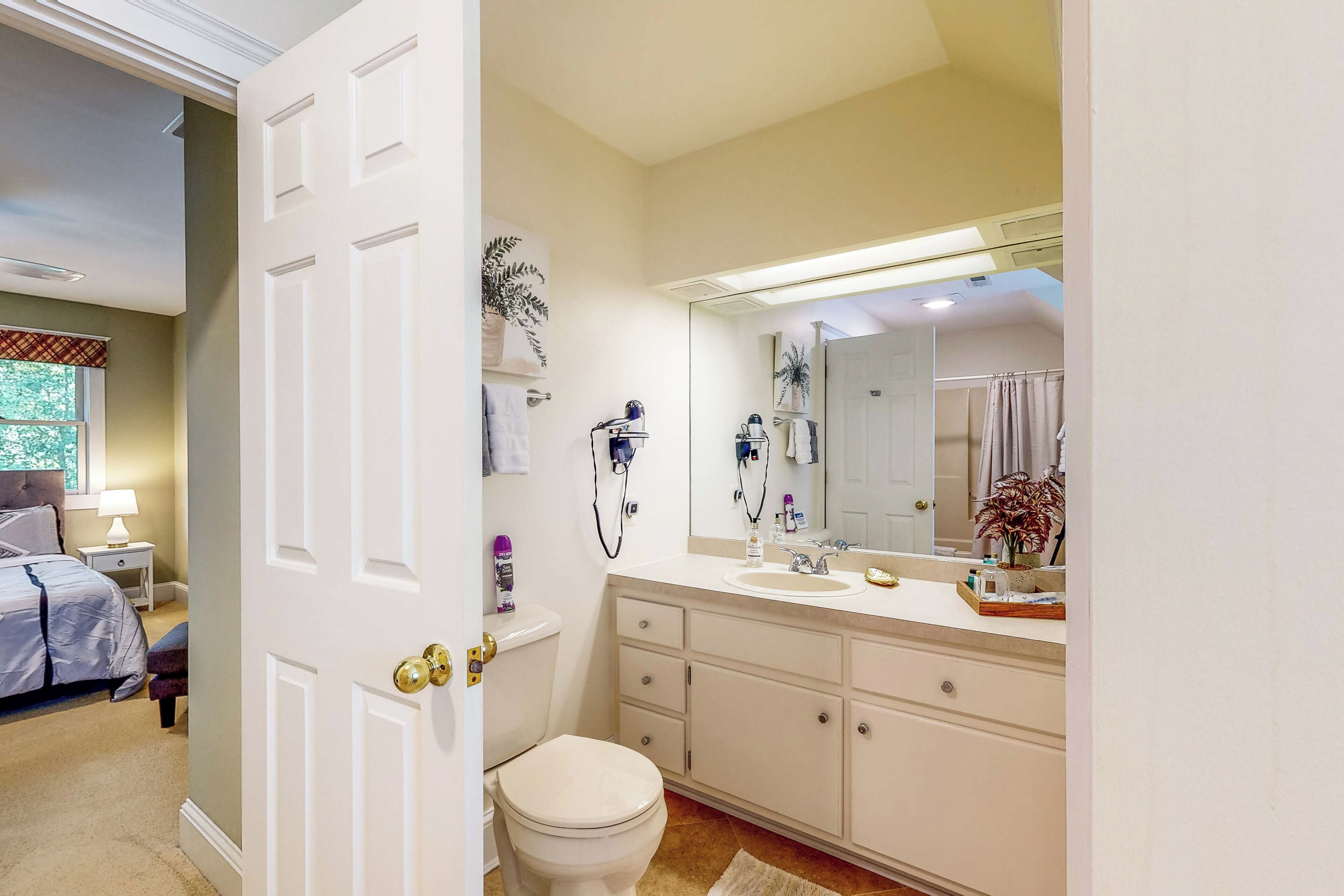 Une salle de bain avec des toilettes, un lavabo et un miroir.