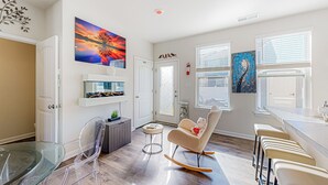 Un salon moderne avec une table à manger en verre, un fauteuil à bascule et un coin bar.
