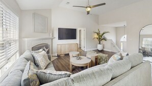 Ein geräumiges Wohnzimmer mit Sofa, Couchtisch und Kamin.