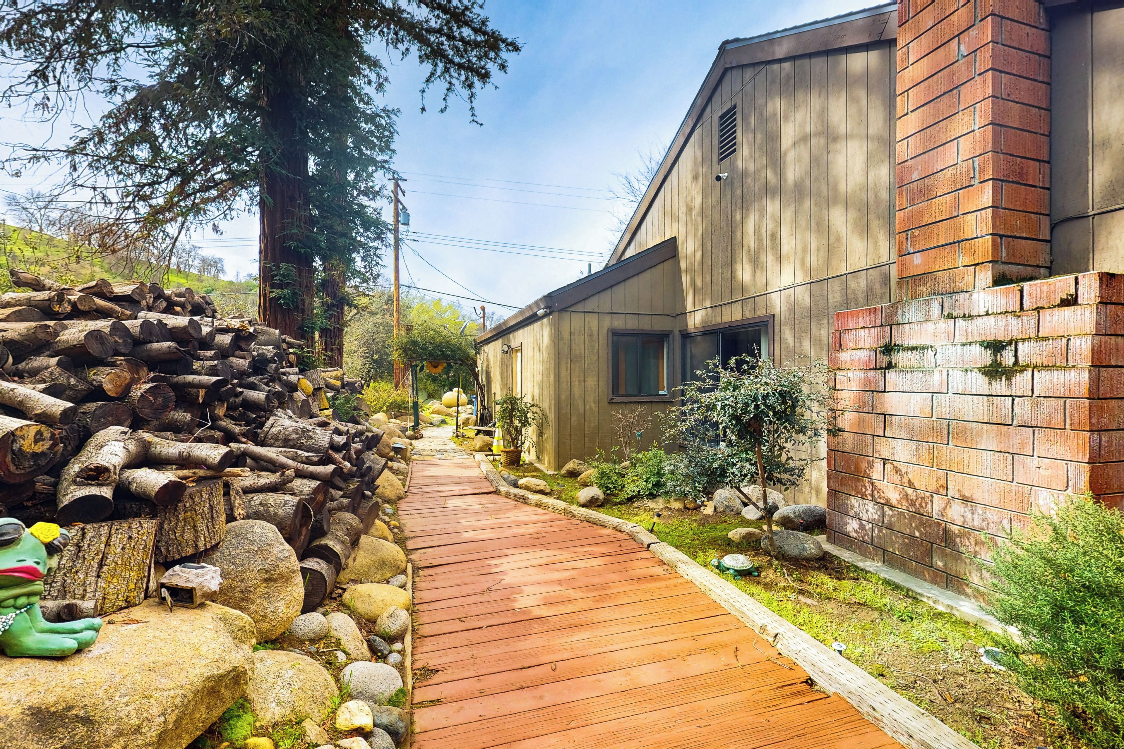 Un sentier en bois mène à un bâtiment moderne dont une partie est en briques et dont l’extérieur est en bois.