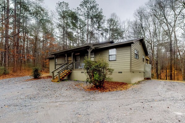 A two-story building with a front porch and a staircase leading to the entrance.