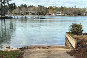 A lakeside view with a dock extending into the water, surrounded by residential buildings and trees.
