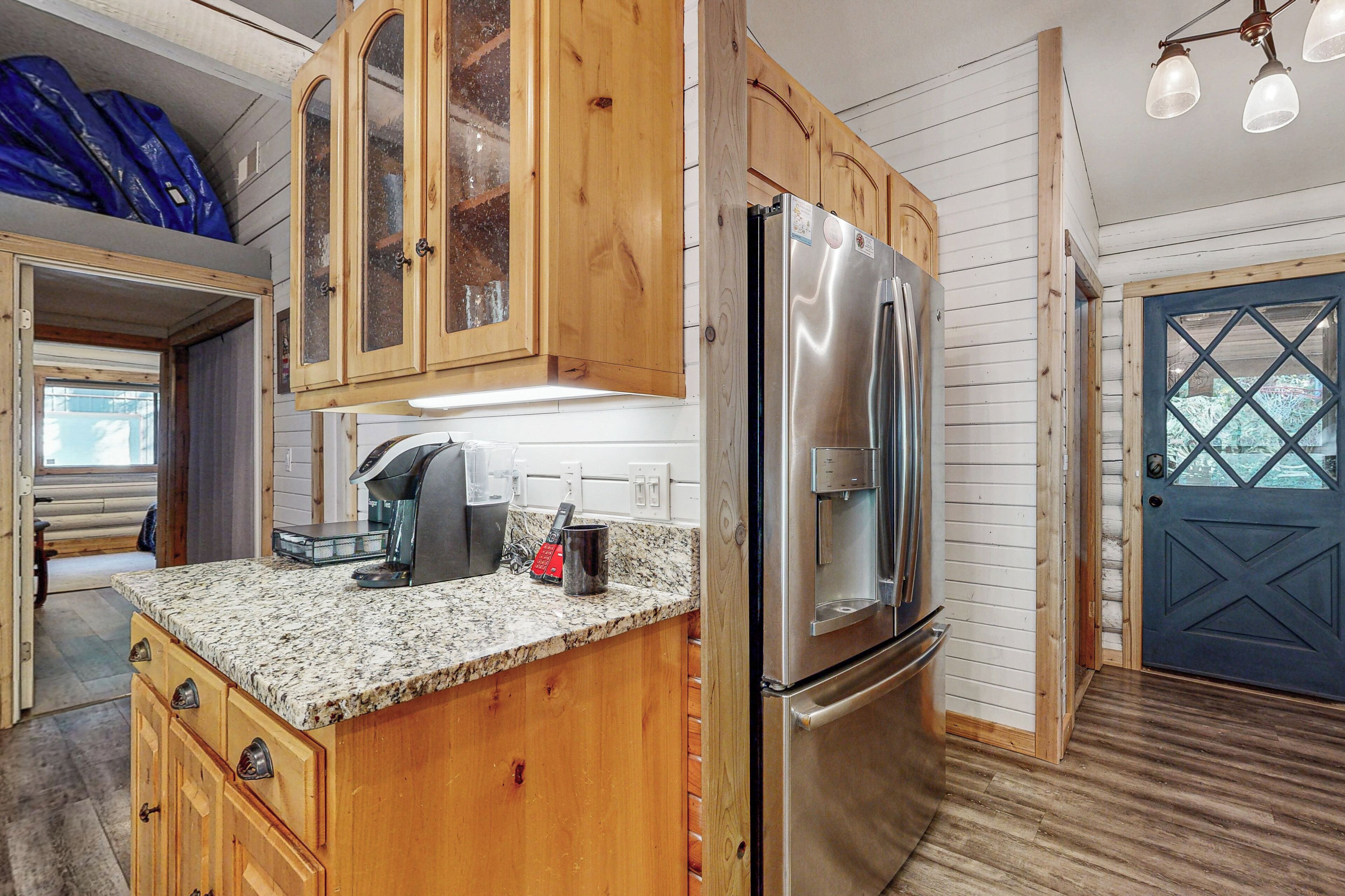 A kitchen with wooden cabinets, a stainless steel refrigerator, and a coffee maker.