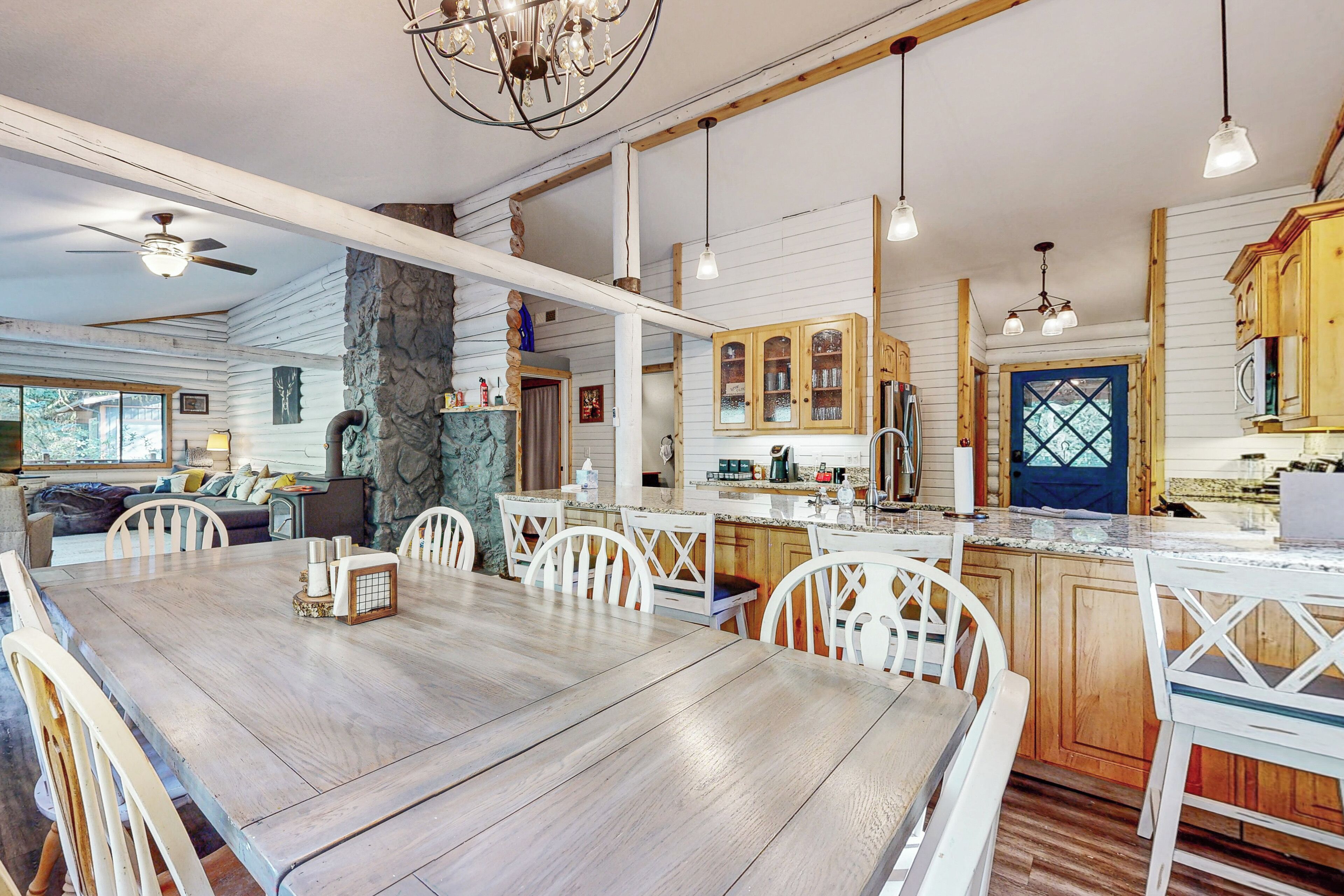 Una cocina amplia con armarios de madera, una isla grande y un comedor con mesa y sillas de madera.
