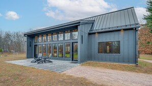 Ein modernes Gebäude mit großen Fenstern und einer überdachten Terrasse.
