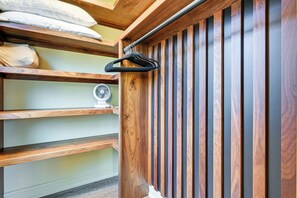 A wooden closet with multiple shelves and a hanging rack. - Walk to Castle Rock Lake! Modern Home w/ Hot Tub (Necedah)