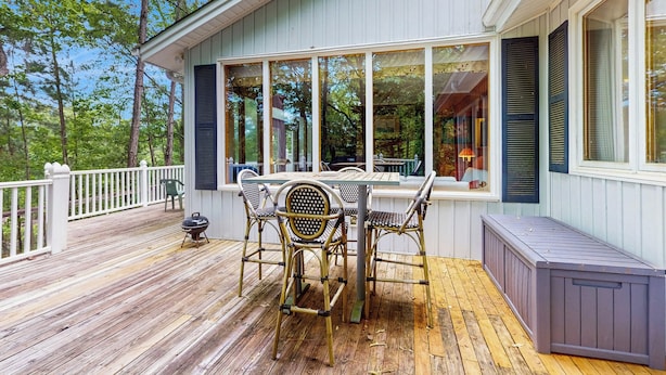 A covered deck with a table and chairs, a grill, and a bench. - Deck & Private Dock! Waccamaw River Retreat (Conway)