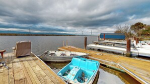 A wooden dock with boats, a chair, and a small blue boat. - 3BR Dog-friendly Home Near River w/ Fire Pit (Bethel Island)