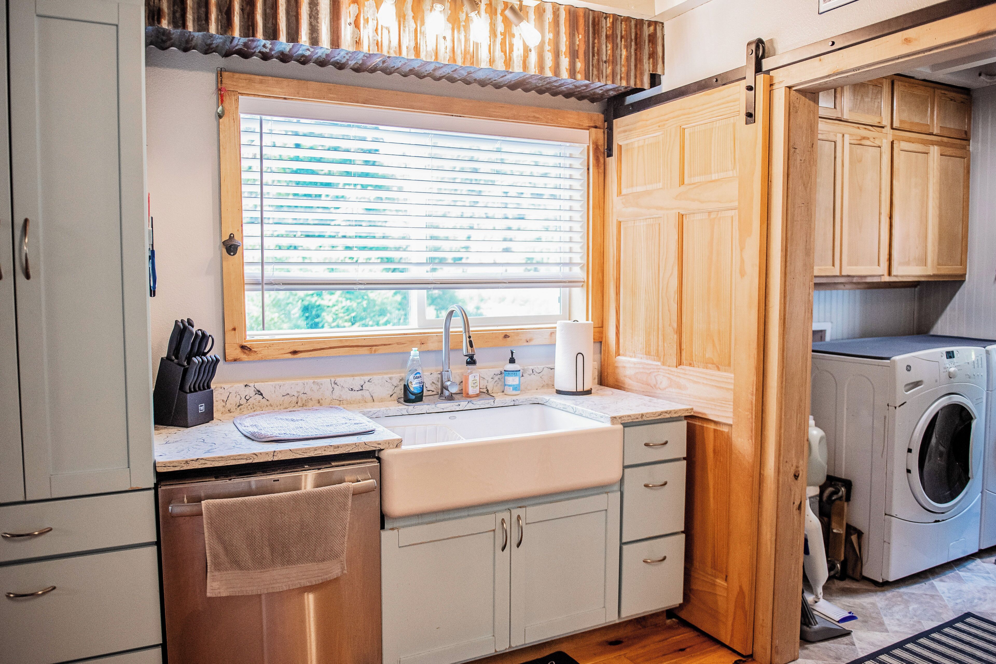 A compact kitchen with a sink, countertop, and wooden cabinets.
