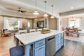 A spacious kitchen with a central island, white cabinetry, and a dining area with wooden chairs and a table. - 4 Seasons of Fun! Walhalla Home w/ Spacious Yard! (Walhalla)